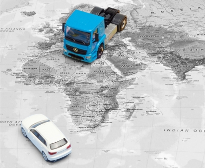 Link to the Herpa Special retailer models, which are only available regionally and from the respective retailers. The image shows a blue Mercedes-Benz tractor unit and a white passenger car, both in miniature, placed on a road map