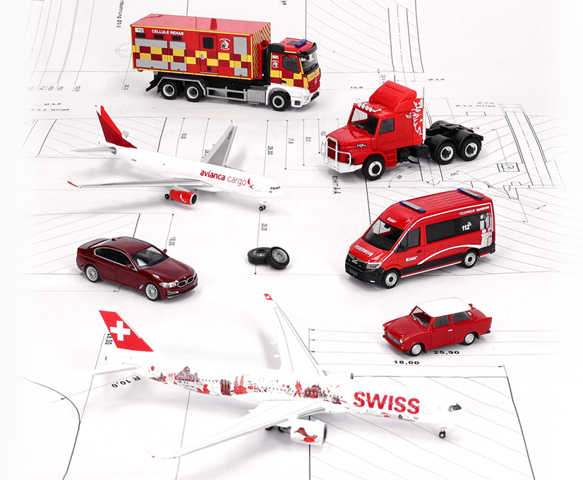 Selection from the Herpa October 2026 delivery: miniature models like planes, emergency vehicles, cars and a tractor, all in red and white, standing on a technical drawing.